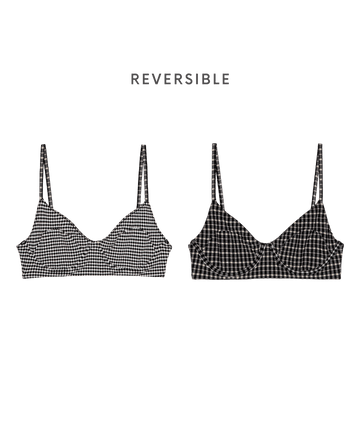 Two front-facing "The Reversible Underwire Bikini Top" by THE GREAT. SP26 SWIM in Black & Cream Check—one in a light, the other in a dark checkered pattern—channeling 1940s bikini style, with "REVERSIBLE" text above.