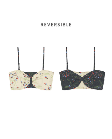 The Reversible Cinched Bandeau by THE GREAT. SP26 SWIM in Windblown Bouquet features a square-cut design, adjustable straps, and two styles: cream floral on one side, black floral on the other.