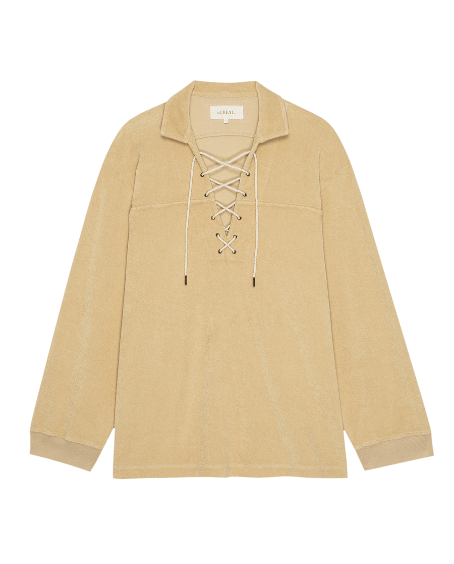The Micro Terry Lace Up Tunic in chamois by THE GREAT. SU25 MICRO TERRY features long sleeves, a collar, white drawstrings at the lace-up front, and a straight hem.