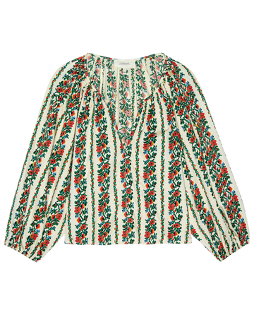 The Chariot Top by THE GREAT. PS26 is a long-sleeve blouse with an open neckline and gathered shoulders, showcasing a tapestry floral red and green pattern on white.