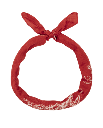 The Stetson Western Bandana in red by THE GREAT. STETSON SP26 features classic white patterns and is tied in a loose knot, forming a circular shape on a plain white background.