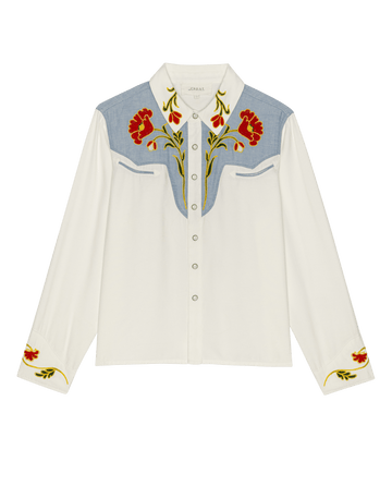 The Embroidered Western Shirt by THE GREAT. STETSON SP26 features a cream and chambray mix, multi-color floral embroidery on chest and cuffs, long sleeves, and snap button closure.