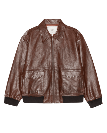 The Flight Jacket in Mahogany Brown by THE GREAT. F26 COLLECTORS features a front zipper, two front flap pockets, and black ribbed cuffs and hem, shown against a white background.