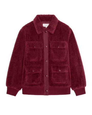 The Patch Pocket Plush Jacket in maroon is a fuzzy long-sleeve jacket with a collar, button-up front, and four buttoned patch pockets.