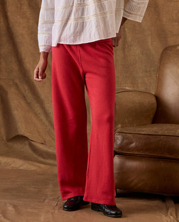A person wearing a white blouse and bright red wide-leg The Fleece Lap Sweatpants.