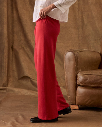 Profile view of a person wearing red, wide-leg The Fleece Lap Sweatpant and black loafers.