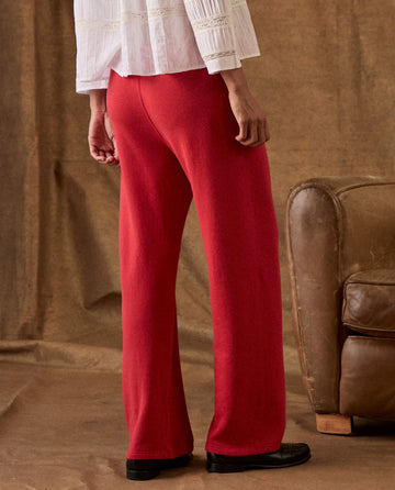 A person viewed from behind, wearing a white blouse and red The Fleece Lap Sweatpant.