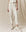 The person is dressed in an off-white ensemble, featuring a cropped top and The Stadium Sweatpant in Washed White by THE GREAT. CORE KNITS, paired perfectly with white sneakers.