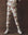 A person wears THE GREAT. F25 D1 The Stadium Sweatpant. Graphic -- Riding Horses Print, featuring a cream hue with brown and red horse graphics, styled with white high-top sneakers against a dark brown backdrop. Soft terry ensures comfort.