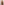 A woman with long blonde hair, wearing a yellow patterned headscarf and THE GREAT. SP25 SWIM The Reversible Mid Rise Brief in Leopard and Black, stands facing a light pink wall with her back to the camera.