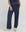A person stands against a plain background wearing THE GREAT. SU25 MICRO TERRY The Micro Terry Victory Sweatpant in Vintage Blue with a matching top and white sneakers, one hand casually in their pocket.