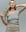 A woman with long blonde hair models THE GREAT. SU25 BABY RIB The Baby Rib Ballet Tee in Heather Grey, paired with matching pants, against a plain background.