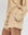 A person wears THE GREAT. SU25 MICRO TERRY The Micro Terry Swing Short in Chamois with a matching sweatshirt, one hand in the pocket; only their lower torso and upper legs are visible.