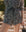 A person wearing THE GREAT. SP25 SWIM's The Delta Short in a black, brown, and white leopard print, paired with a small bag and styled unexpectedly with a long-sleeve button-up romper.