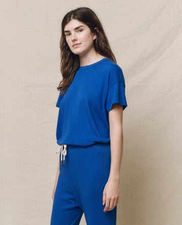 Someone wearing THE GREAT. SP25 KNITS 'The Boxy Crew' in Bright Cobalt stands in front of a beige backdrop, giving off a relaxed, casual wear vibe while looking at the camera.