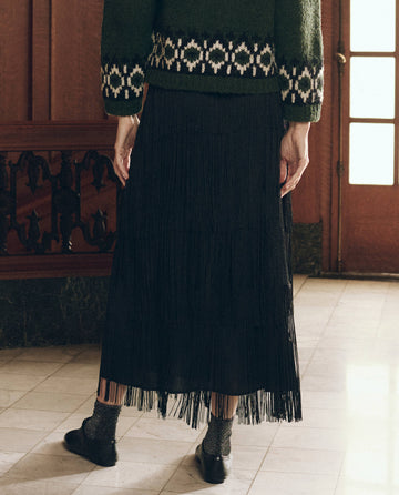 Black The Fringe Skirt worn with a dark green patterned sweater and black flats.