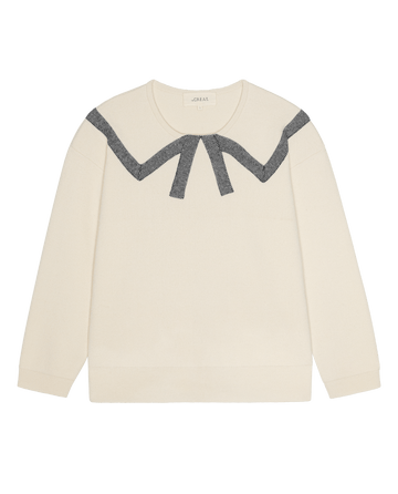THE GREAT. H26 The Bow Sweater in cream, featuring a long-sleeve crewneck silhouette with a dark, patterned bow design across the chest.