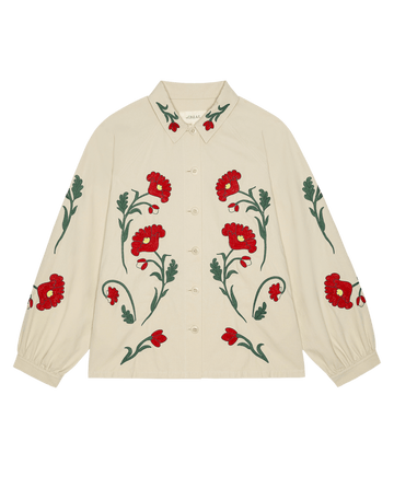 The GREAT. STETSON SP26 The Western Embroidered Commodore Jacket in cream features red and green floral embroidery on the front, sleeves, and cuffs, channeling the charm of a classic Western jacket.