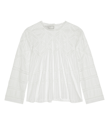 The Lattice Lace Victorian Top by THE GREAT. F26 COLLECTORS features a loose-fitting white silhouette, with a geometric lattice-inspired texture adorning the upper section and pleated detailing on the lower half.