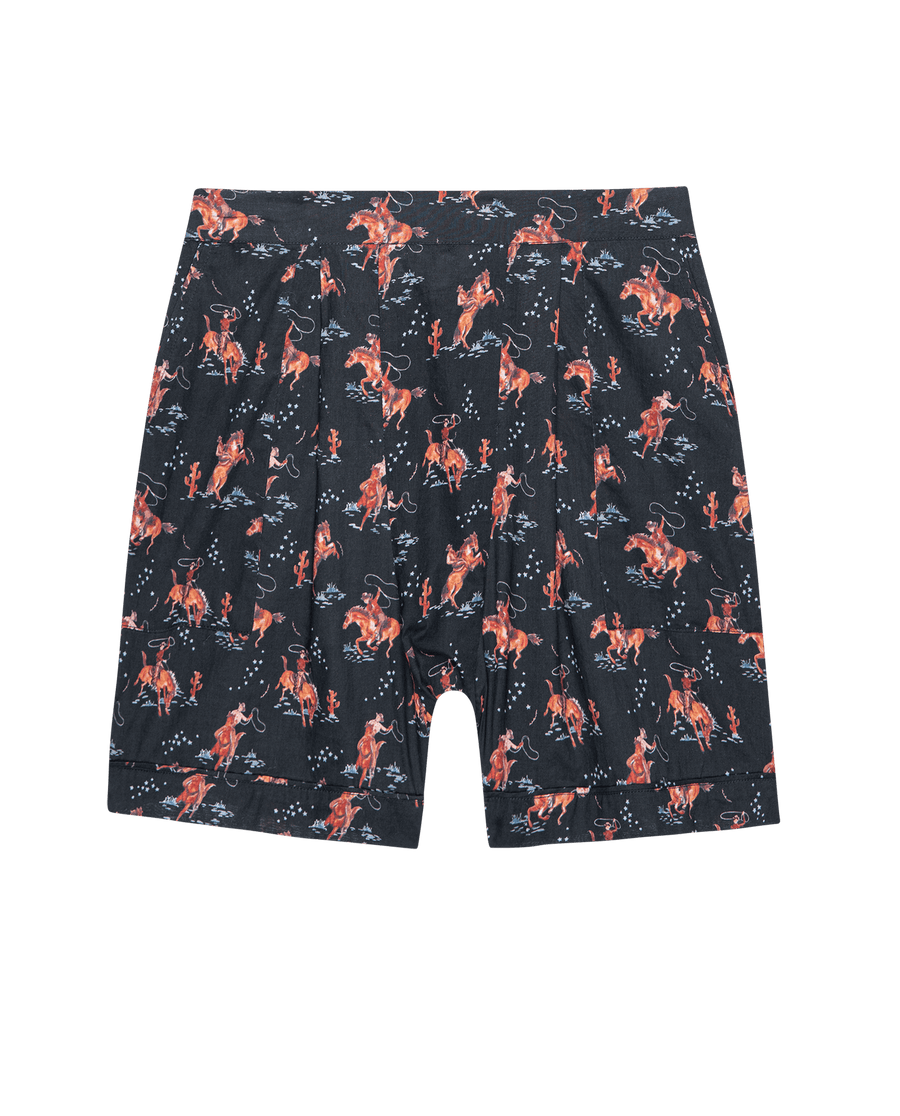 The Square Pajama Short in Navy Cowboy by THE GREAT. SP25 SLEEP features a navy base with red and orange cowboy prints—perfect for pairing with your favorite pajama top or wearing as stylish shorts at home.