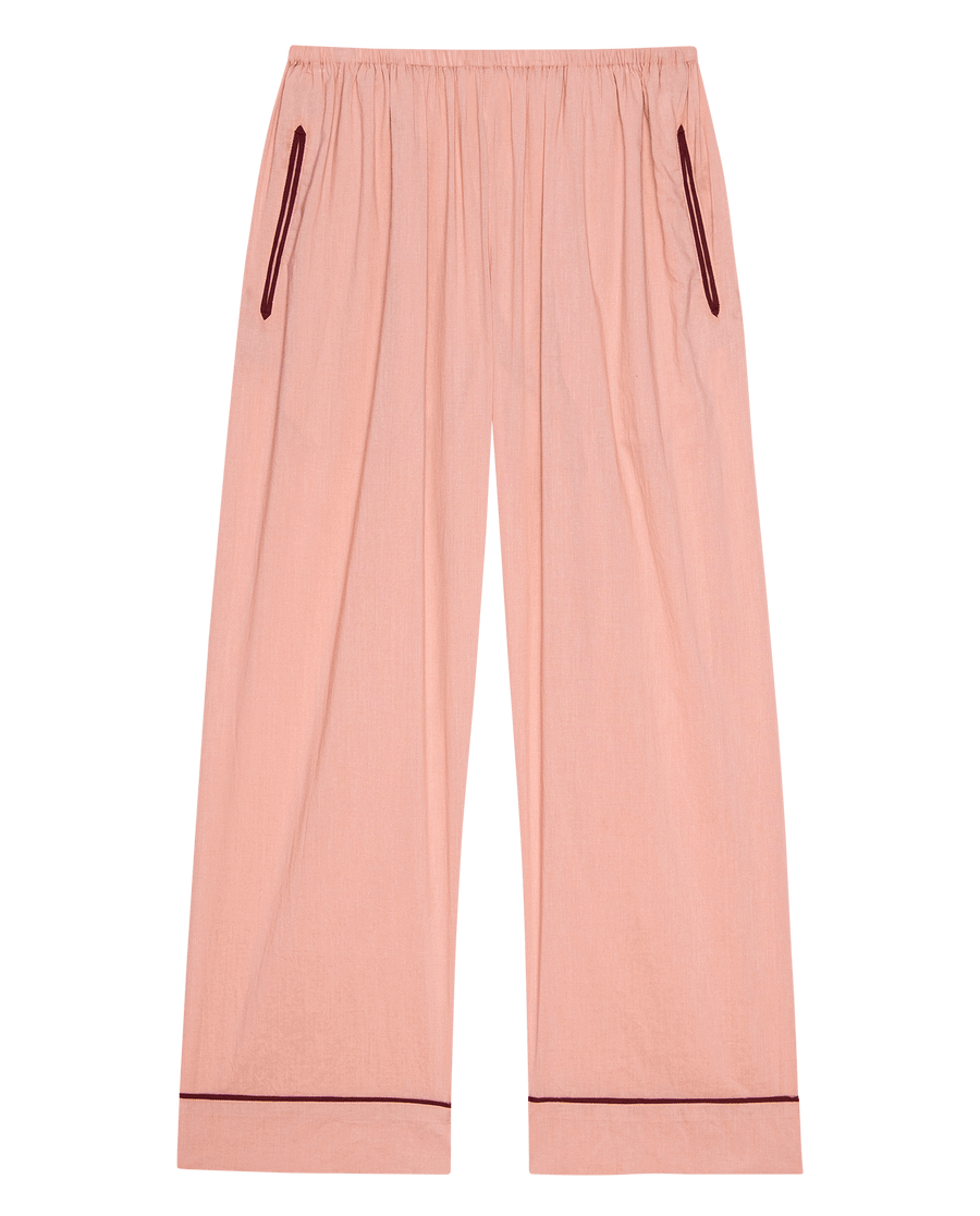 The Western Easy Sleep Pant -- Rose Bloom by THE GREAT. SP25 SLEEP features light pink fabric, an elastic waistband, and maroon piping on pockets and cuffs for stylish comfort, shown against a white background.