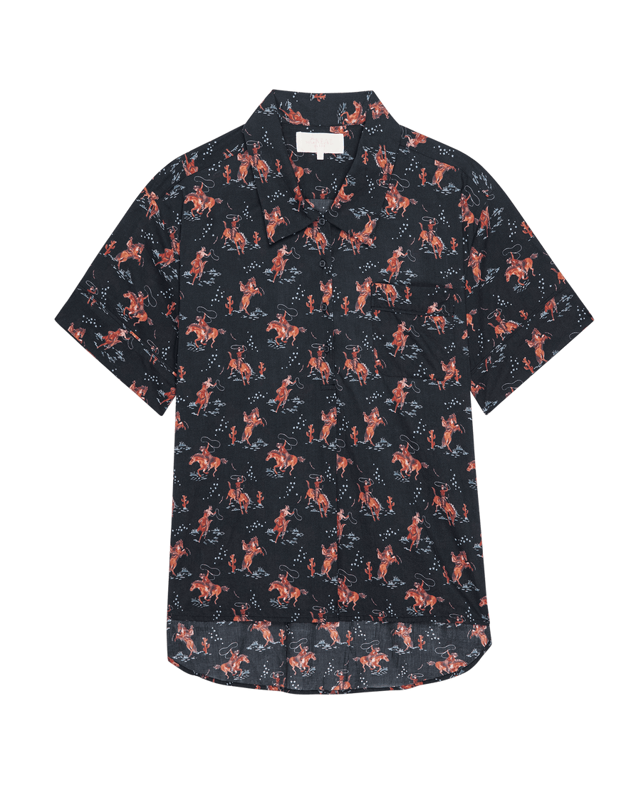 The Short Sleeve Pajama Shirt by THE GREAT. SP25 SLEEP features a navy background with an all-over red and tan cowboy print.