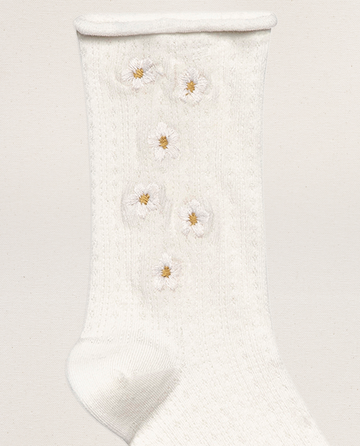 THE GREAT. SP25 POINTELLE SOCKS – The Pointelle Sock in True White features a textured knit and daisy embroidery with white petals and yellow centers.