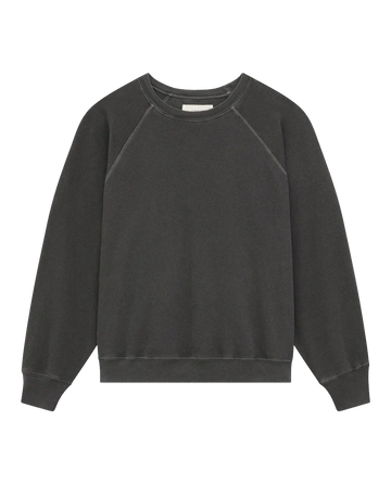 A cozy vintage appeal is offered by The Shrunken Sweatshirt in Washed Black, featuring long sleeves and ribbed cuffs, from THE GREAT. CORE KNITS.