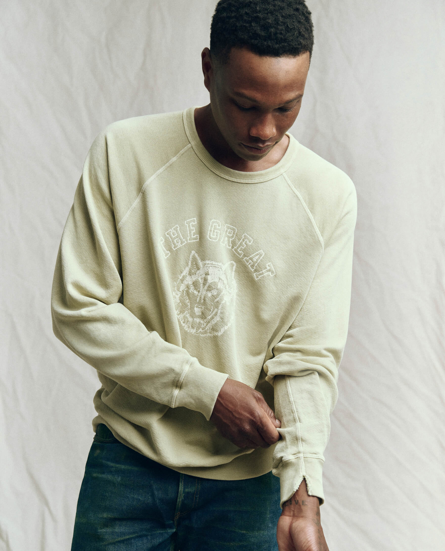 The Men's College Sweatshirt. -- Dusty Sweetgrass with Field Wolf Graphic