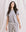 A person stands in front of a light-colored backdrop, wearing The Little Tee in Heather Grey by THE GREAT. SP22 APRILCAP and matching pants with a drawstring waist. Embracing a comfortable fit, they have long, dark hair.